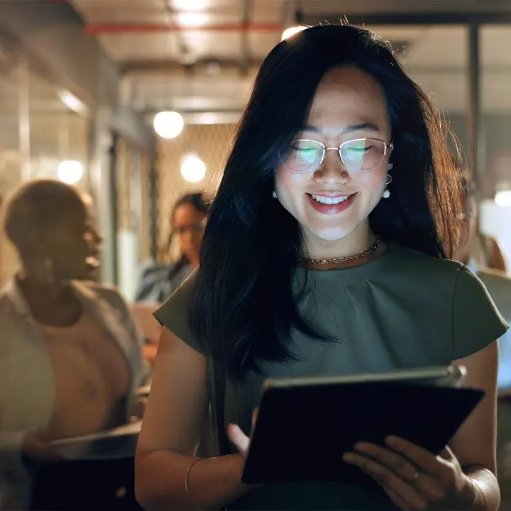 A colleague smiling as she works through a change on a tablet